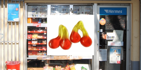 Ein Kiosk namens Kaffeepause. Im Vordergrund sind zwei Gummibärchen-Kirschen abgebildet