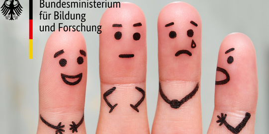 vier Fingerinnenseiten, die mit Gesichtern und Händen bemalt sind. Sie drücken Emotionen aus, wie Wut, Trauer und Fröhlichkeit. Oben links befindet sich das Logo des BMBF